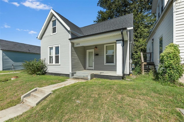 view of front of house featuring a porch, a front lawn, and a shingled roof