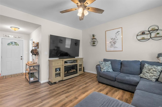 living area featuring ceiling fan, wood finished floors, and baseboards