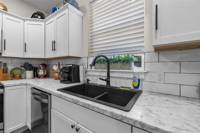 kitchen with stainless steel dishwasher, a sink, decorative backsplash, and white cabinetry