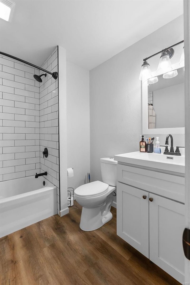 bathroom featuring toilet, vanity, wood finished floors, and shower / tub combo with curtain
