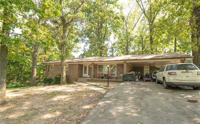 ranch-style home with asphalt driveway, an attached carport, and brick siding