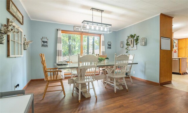 dining room featuring crown molding, wood finished floors, and baseboards