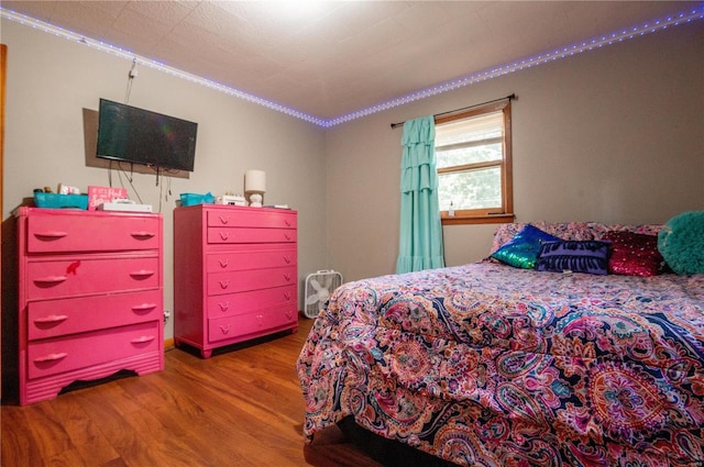 bedroom featuring ornamental molding and wood finished floors