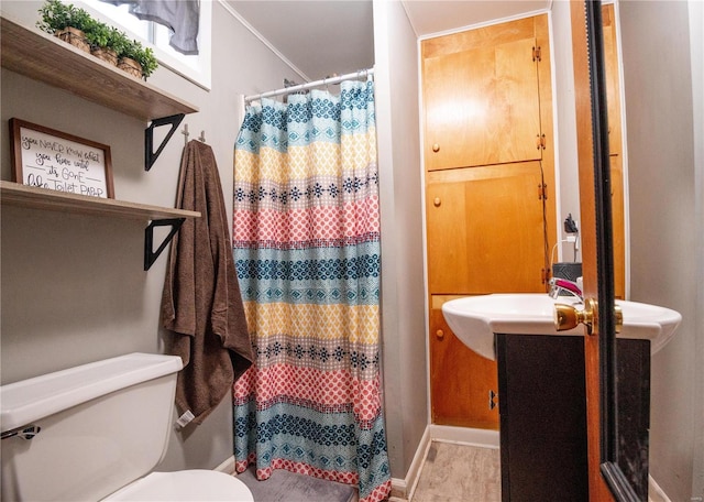 bathroom featuring toilet, a shower with curtain, baseboards, and vanity