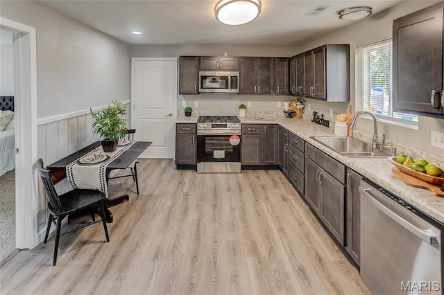 8546 US Highway 50, Lebanon, IL 62254 - kitchen with stainless steel appliances, dark brown cabinetry, light countertops, light wood finished floors, and wainscoting