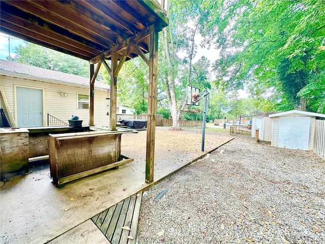 view of patio featuring a shed, fence, and an outdoor structure