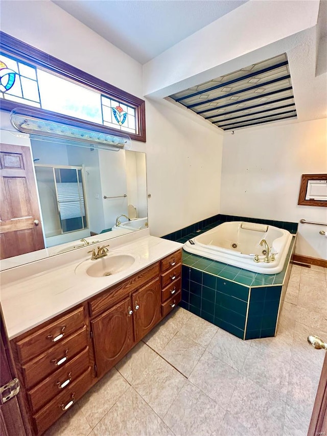 bathroom featuring tile patterned flooring, vanity, and a jetted tub