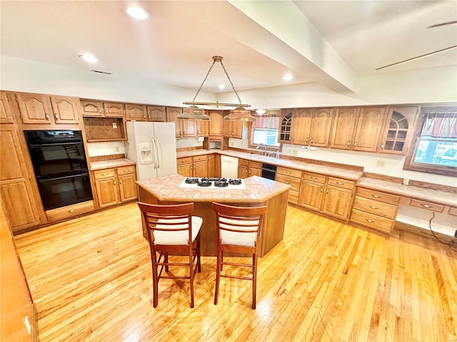 kitchen with white appliances, a sink, light wood-style floors, light countertops, and recessed lighting
