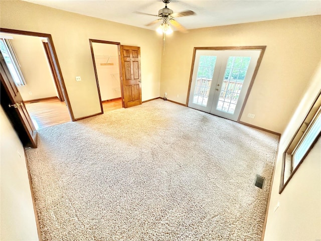unfurnished bedroom with french doors, access to exterior, light colored carpet, baseboards, and a spacious closet