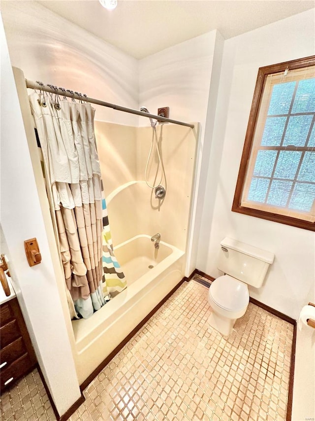 full bathroom featuring shower / tub combo with curtain, toilet, and baseboards