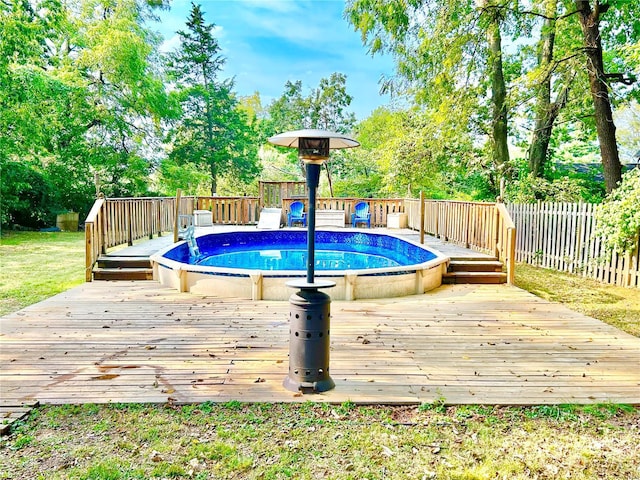 view of pool with a fenced backyard, a wooden deck, and view of wooded area