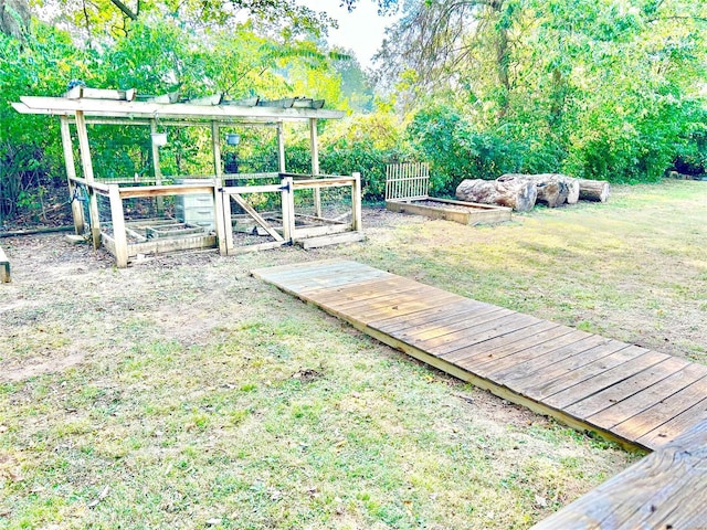 view of grassy yard featuring a vegetable garden
