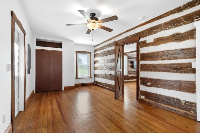 1137 Main St, Maeystown, IL 62256 - unfurnished bedroom featuring hardwood / wood-style flooring, baseboards, wood walls, and a ceiling fan