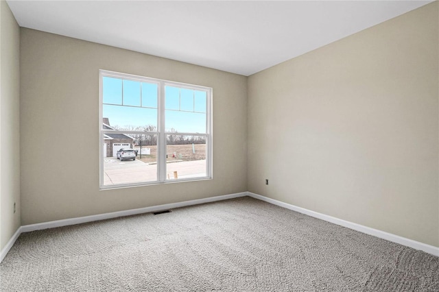 spare room featuring baseboards and carpet flooring
