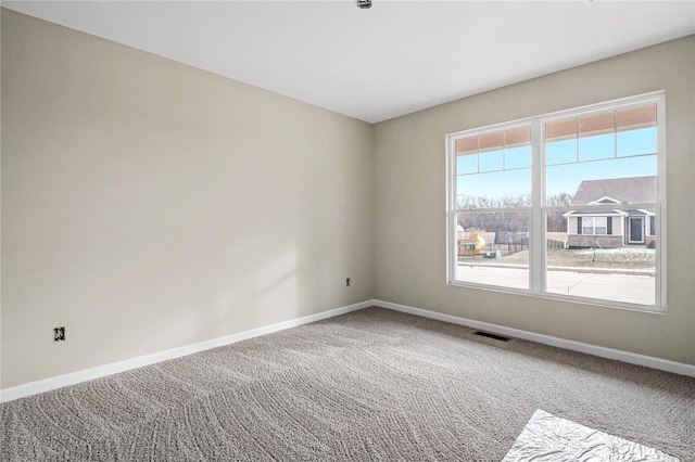empty room featuring baseboards and carpet floors