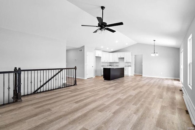 unfurnished living room with lofted ceiling, ceiling fan, light wood finished floors, and baseboards