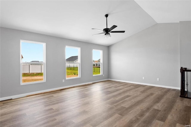 unfurnished living room with vaulted ceiling, wood finished floors, ceiling fan, and baseboards