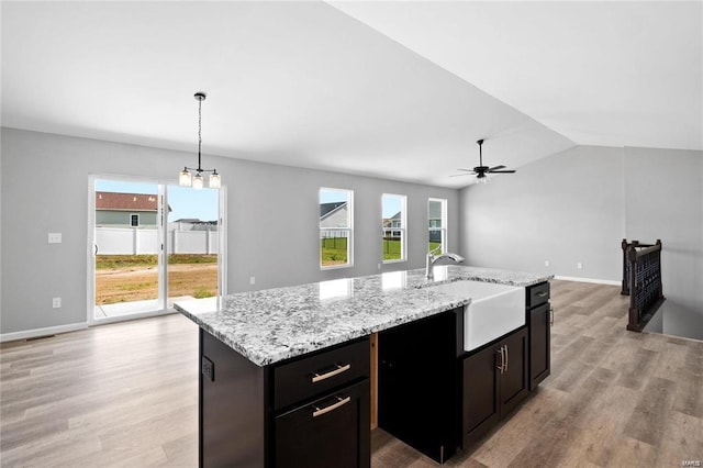 kitchen featuring a sink, light wood-style flooring, healthy amount of natural light, and lofted ceiling
