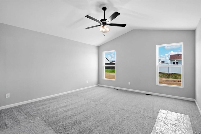 unfurnished room featuring carpet floors, baseboards, vaulted ceiling, and ceiling fan