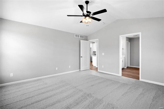 unfurnished bedroom featuring carpet floors, lofted ceiling, baseboards, and a ceiling fan