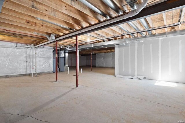 unfinished basement featuring water heater and heating unit
