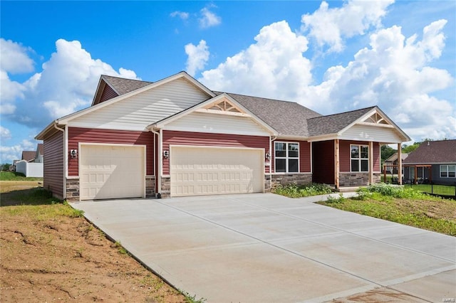 craftsman-style house featuring an attached garage, stone siding, a shingled roof, and concrete driveway