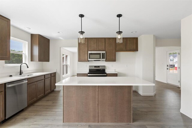 102 Harrow Dr, Ofallon, MO 63385 - kitchen featuring stainless steel appliances, a sink, light wood finished floors, a kitchen island, and recessed lighting