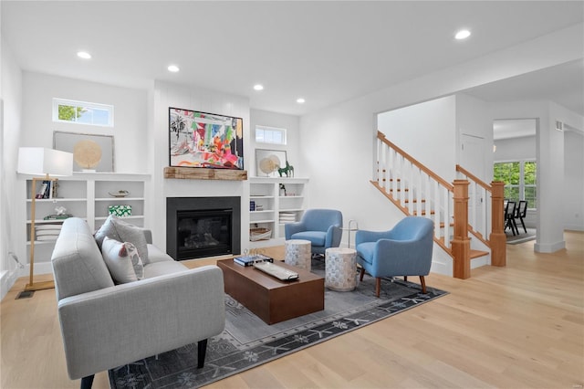 2017 Woodsey Dr, Brentwood, MO 63144 - living room with wood finished floors, recessed lighting, a glass covered fireplace, stairway, and baseboards