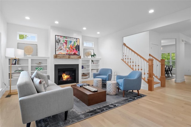 2017 Woodsey Dr, Brentwood, MO 63144 - living area featuring wood finished floors, a glass covered fireplace, recessed lighting, stairway, and baseboards