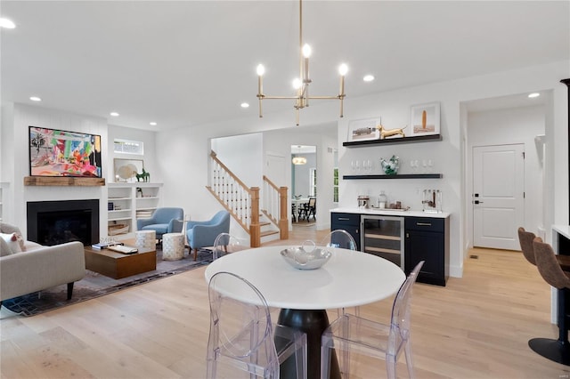 2017 Woodsey Dr, Brentwood, MO 63144 - dining space featuring bar, beverage cooler, light wood finished floors, stairway, and a chandelier