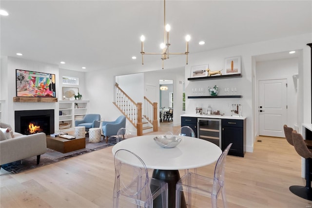 2017 Woodsey Dr, Brentwood, MO 63144 - dining room featuring wine cooler, bar area, light wood-type flooring, stairs, and a large fireplace