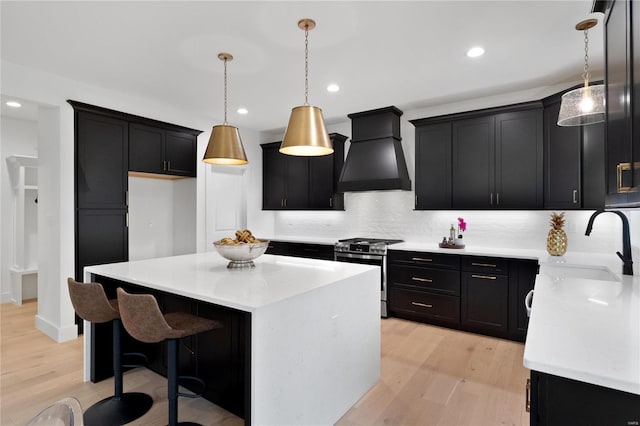 2017 Woodsey Dr, Brentwood, MO 63144 - kitchen with custom exhaust hood, stainless steel range with gas cooktop, dark cabinetry, a sink, and recessed lighting