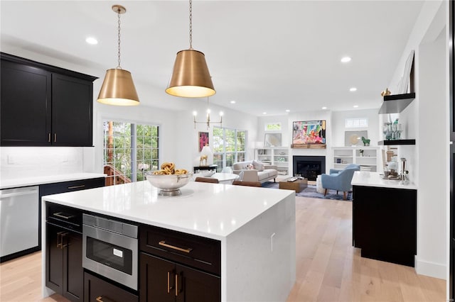 2017 Woodsey Dr, Brentwood, MO 63144 - kitchen with stainless steel appliances, light wood finished floors, light countertops, recessed lighting, and a fireplace