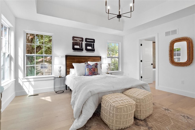 2017 Woodsey Dr, Brentwood, MO 63144 - bedroom with light wood-style floors, a chandelier, baseboards, and a raised ceiling