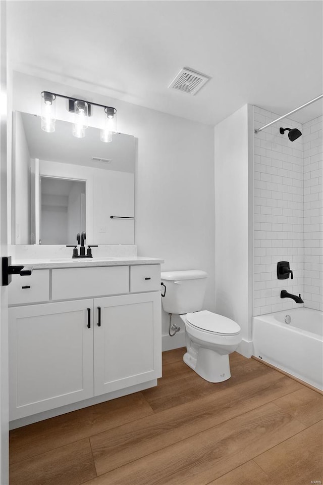 2017 Woodsey Dr, Brentwood, MO 63144 - bathroom featuring toilet, wood finished floors, vanity, and bathtub / shower combination