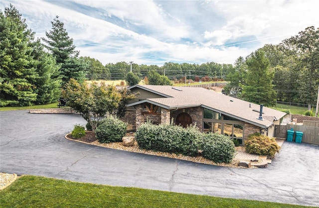 10010 Edmondson Hills Dr, Rolla, MO 65401 - view of home's exterior with stone siding, fence, a gate, and a shingled roof