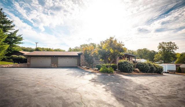 10010 Edmondson Hills Dr, Rolla, MO 65401 - view of front of home with asphalt driveway, a garage, and stone siding