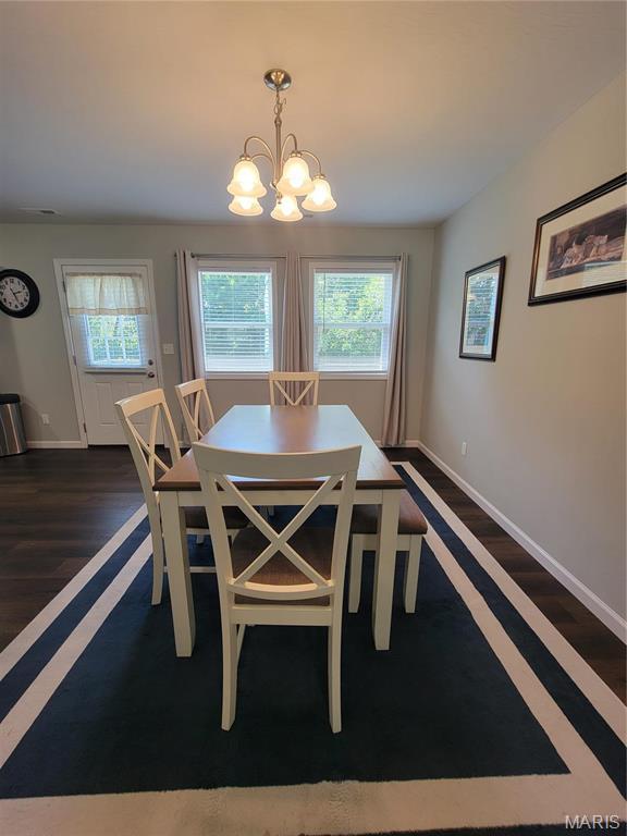 301 S Sloan St, Lebanon, MO 65536 - dining room with a chandelier, baseboards, plenty of natural light, and dark wood-style flooring