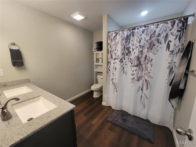 301 S Sloan St, Lebanon, MO 65536 - full bathroom featuring wood finished floors, toilet, double vanity, baseboards, and curtained shower