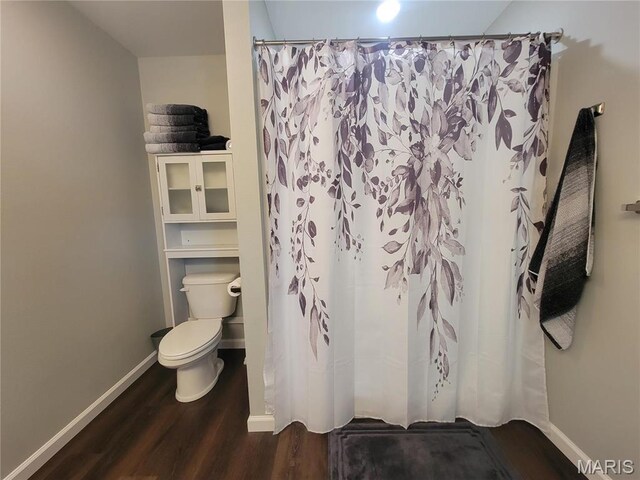 301 S Sloan St, Lebanon, MO 65536 - bathroom featuring wood finished floors, baseboards, toilet, and a shower with shower curtain