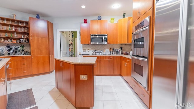 kitchen with stainless steel appliances, backsplash, light countertops, a center island, and recessed lighting