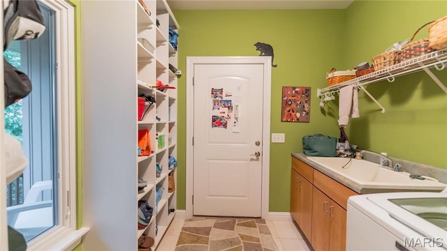 laundry room featuring cabinet space, washer / clothes dryer, baseboards, and light tile patterned floors