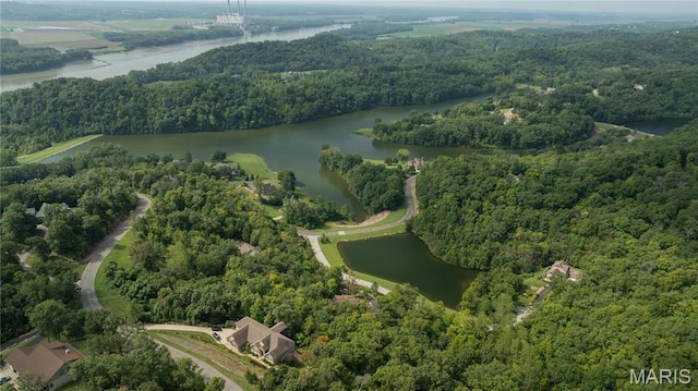 aerial view of property and surrounding area with a forest and a nearby body of water