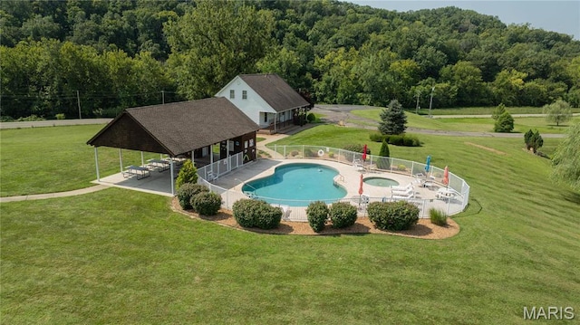 community pool featuring a forest view and a patio