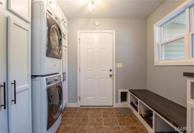 382 Christina Ln, Poplar Bluff, MO 63901 - laundry room featuring stacked washer / dryer, cabinet space, and dark tile patterned flooring