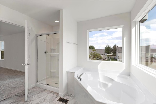 full bath featuring a stall shower, a garden tub, and baseboards