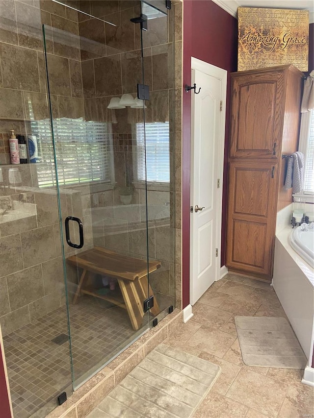 bathroom with a garden tub, a stall shower, and stone finish flooring