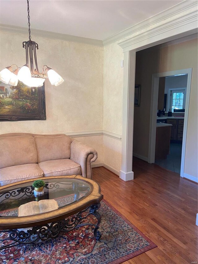 living area featuring crown molding, wood finished floors, and baseboards