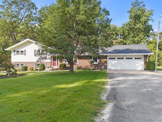 view of front facade with brick siding, driveway, a garage, and a front yard