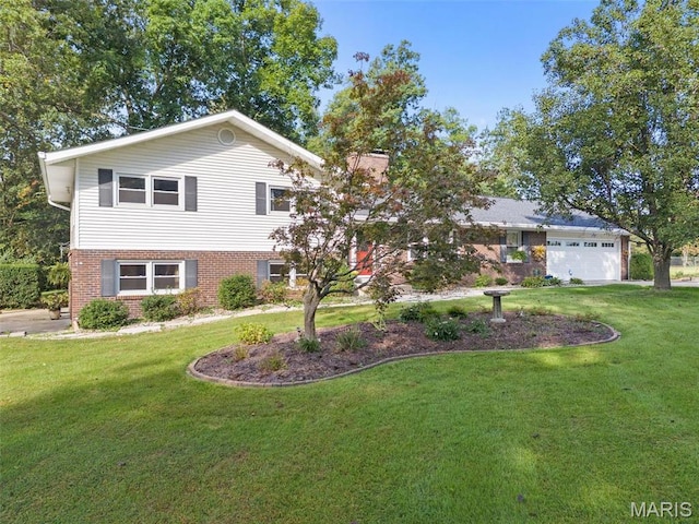 tri-level home with a front yard, brick siding, and a garage